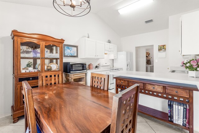 dining space with lofted ceiling, a chandelier, and light tile patterned flooring