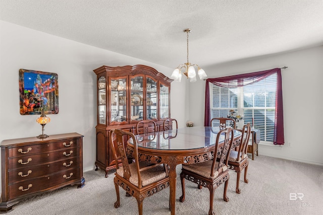 carpeted dining space with a notable chandelier and a textured ceiling