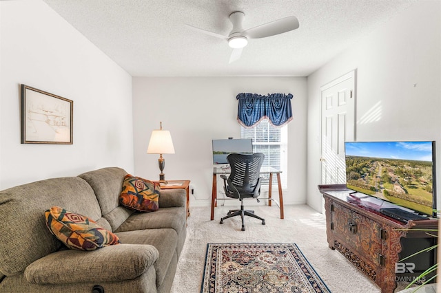 office space with a textured ceiling, light colored carpet, and ceiling fan