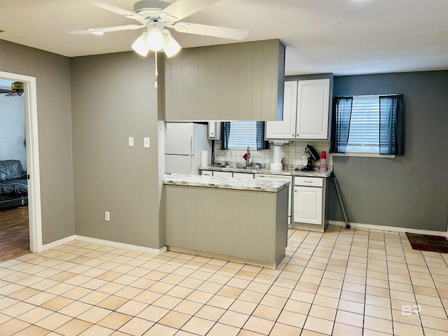 kitchen featuring tasteful backsplash, ceiling fan, white cabinets, and white fridge