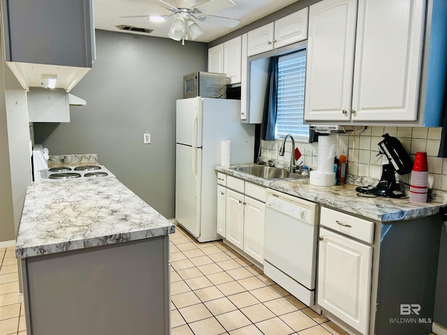 kitchen with tasteful backsplash, white appliances, sink, and white cabinets