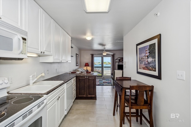 kitchen with white cabinets, dark countertops, a ceiling fan, light tile patterned floors, and white appliances