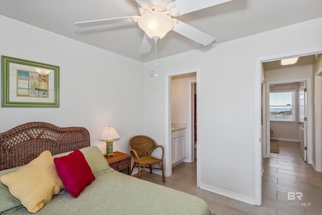 bedroom with a ceiling fan, baseboards, and ensuite bathroom
