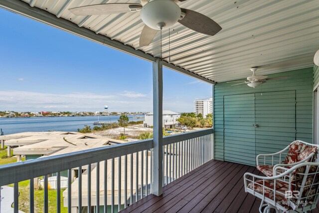 wooden deck with a ceiling fan and a water view