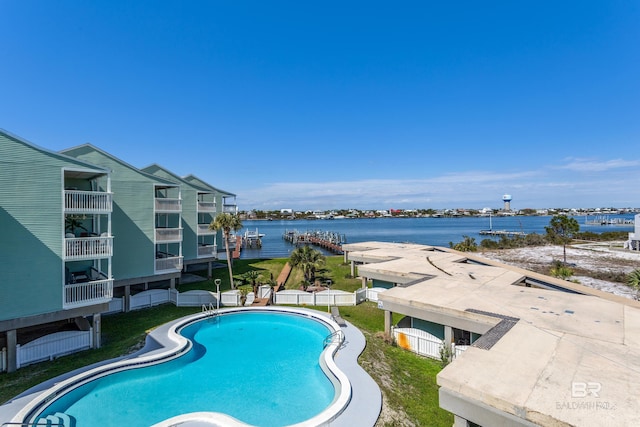 pool with a water view and fence