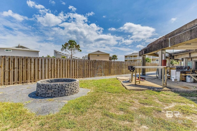 view of yard with a fenced backyard, an outdoor fire pit, and a patio