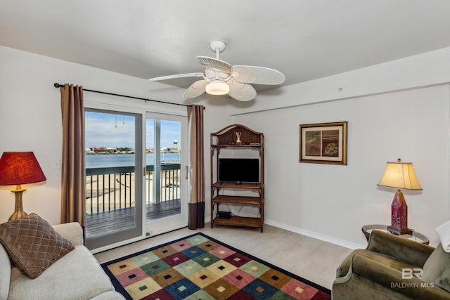 living room featuring a ceiling fan and baseboards