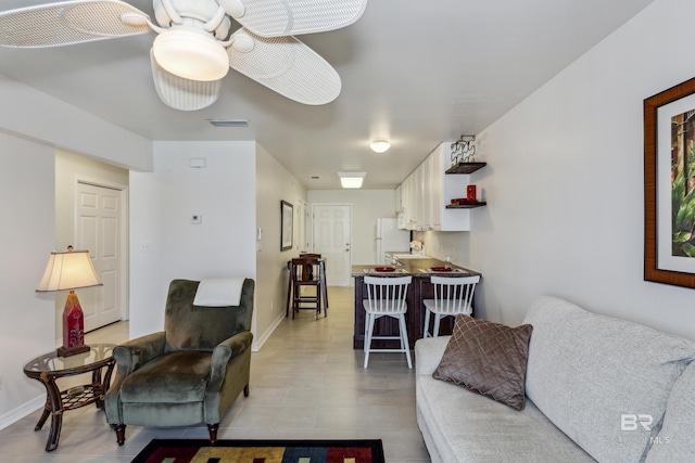living area with baseboards, visible vents, and light tile patterned floors