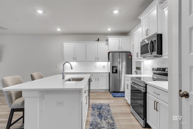 9983 Willet Way, Foley, AL 36535 - kitchen featuring stainless steel appliances, a breakfast bar area, light wood-type flooring, decorative backsplash, and recessed lighting