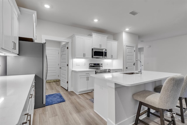 9983 Willet Way, Foley, AL 36535 - kitchen with stainless steel appliances, white cabinetry, light wood-style flooring, light countertops, and recessed lighting