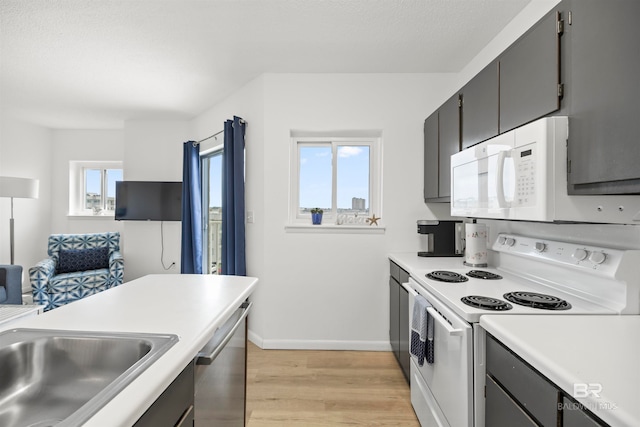 kitchen featuring white appliances, sink, and light wood-type flooring