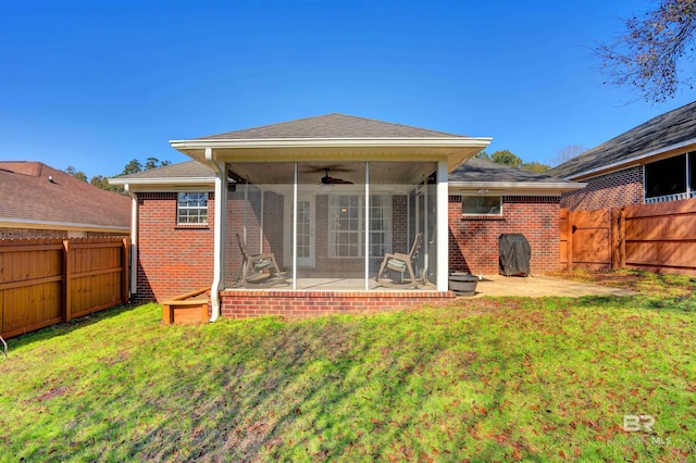 back of house featuring ceiling fan, a patio, a sunroom, and a lawn