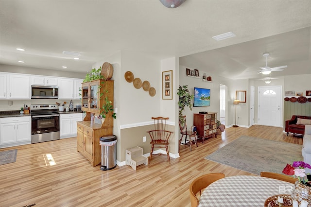 living room with light hardwood / wood-style floors and ceiling fan