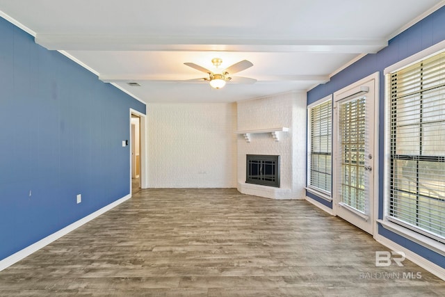 unfurnished living room featuring hardwood / wood-style flooring, beamed ceiling, and a wealth of natural light