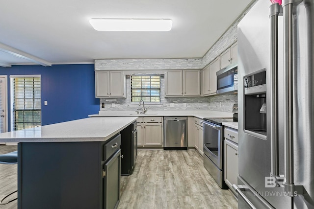 kitchen featuring gray cabinetry, stainless steel appliances, light hardwood / wood-style floors, and sink