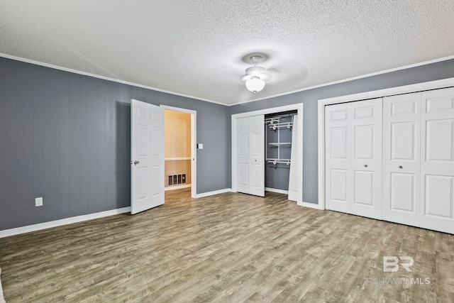 unfurnished bedroom with ceiling fan, light hardwood / wood-style flooring, crown molding, and a textured ceiling