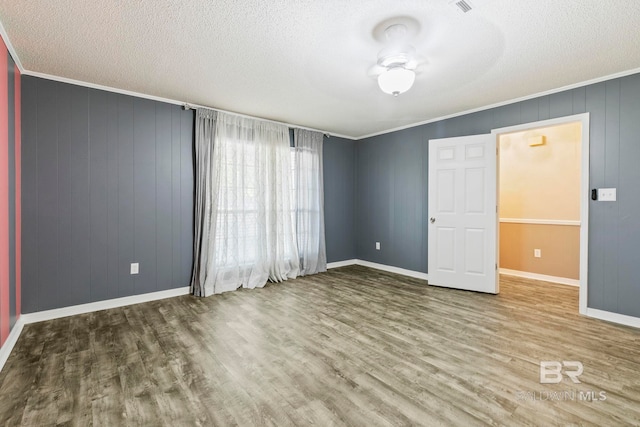 unfurnished bedroom featuring ornamental molding, a textured ceiling, and hardwood / wood-style flooring