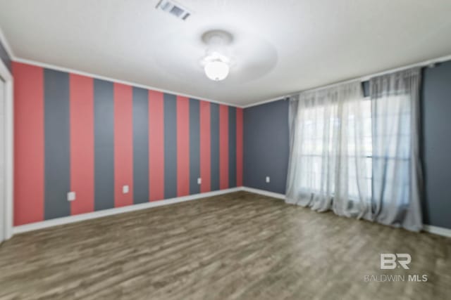 spare room with crown molding and dark wood-type flooring