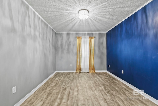 empty room with hardwood / wood-style floors, a textured ceiling, and ornamental molding