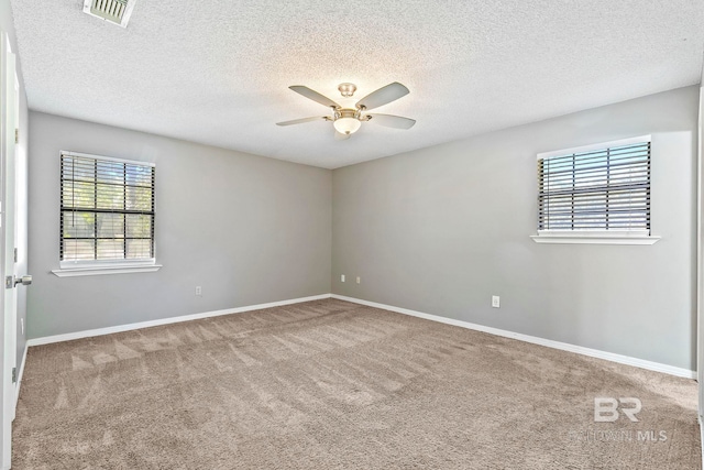 carpeted spare room featuring a textured ceiling and ceiling fan