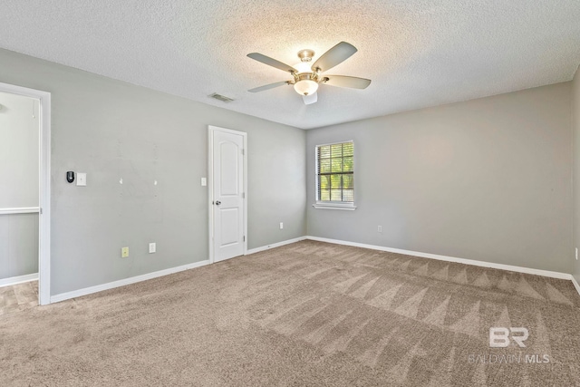 spare room featuring carpet flooring, a textured ceiling, and ceiling fan