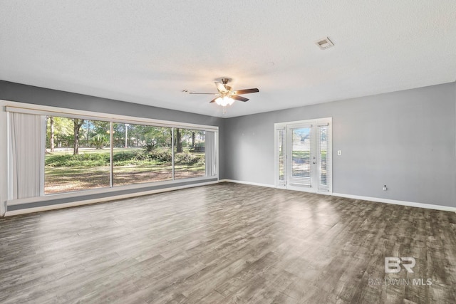 unfurnished room featuring hardwood / wood-style floors, ceiling fan, and a textured ceiling