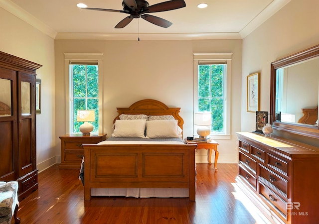 bedroom featuring multiple windows, ceiling fan, and dark hardwood / wood-style floors