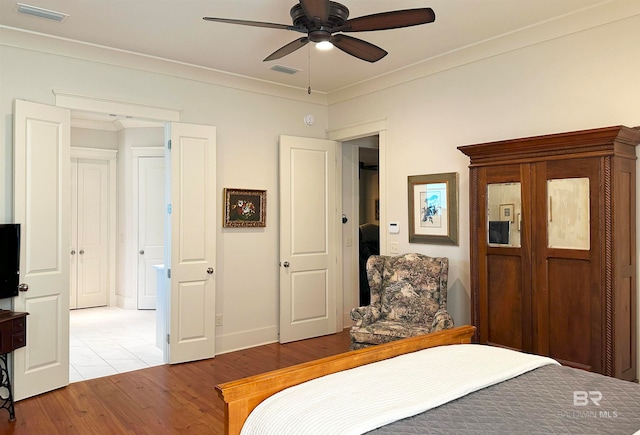 bedroom featuring crown molding, hardwood / wood-style floors, and ceiling fan