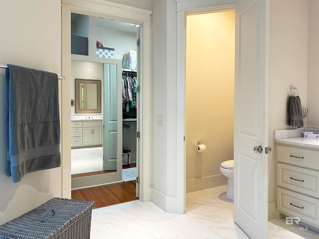 bathroom with vanity, toilet, and hardwood / wood-style floors