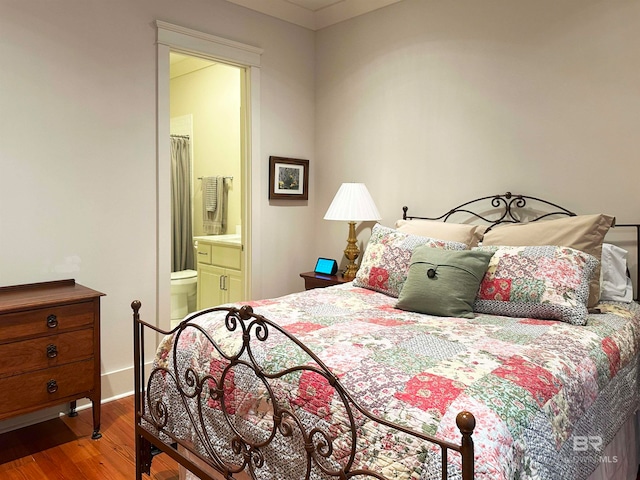 bedroom with hardwood / wood-style flooring and ensuite bathroom