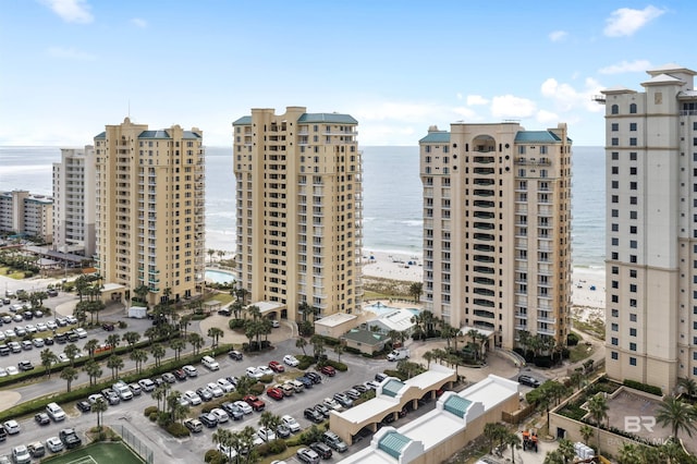 view of building exterior featuring a water view and a beach view