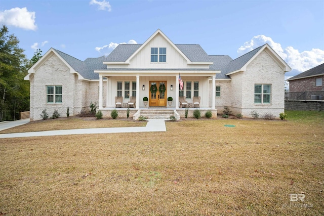 view of front of house featuring a front yard, a porch, and french doors