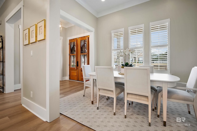 dining room featuring crown molding and light hardwood / wood-style flooring