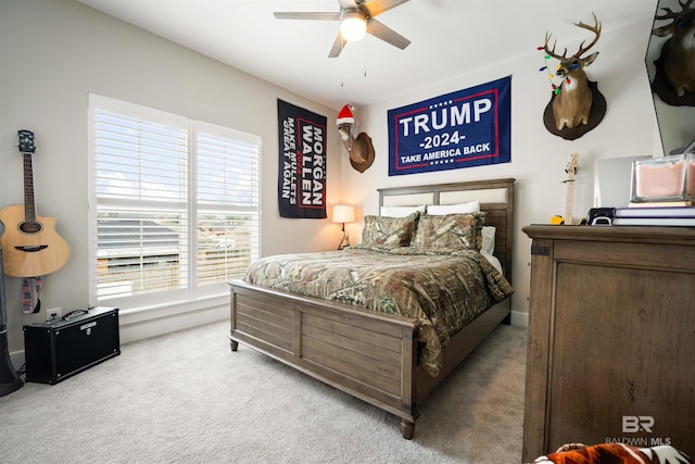 bedroom with multiple windows, ceiling fan, and light colored carpet