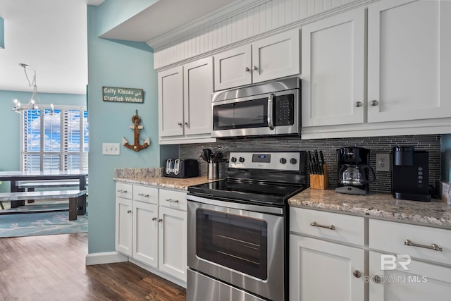 25250 Perdido Beach Blvd Unit 304E, Orange Beach, AL 36561 - kitchen with dark wood finished floors, white cabinets, appliances with stainless steel finishes, a notable chandelier, and backsplash