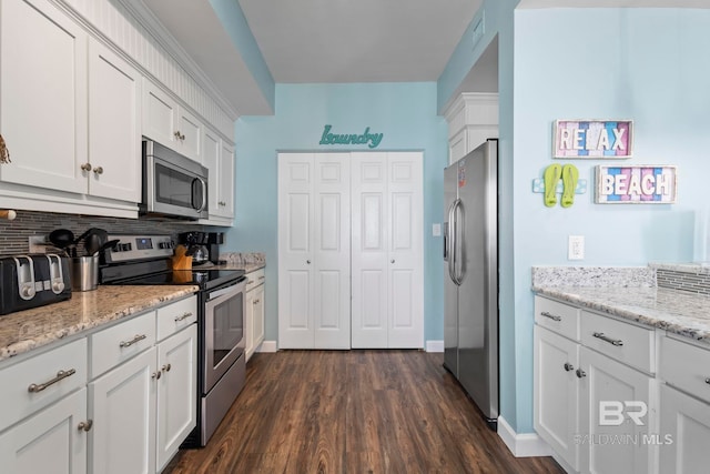 25250 Perdido Beach Blvd Unit 304E, Orange Beach, AL 36561 - kitchen with light stone counters, visible vents, stainless steel appliances, dark wood-type flooring, and white cabinetry