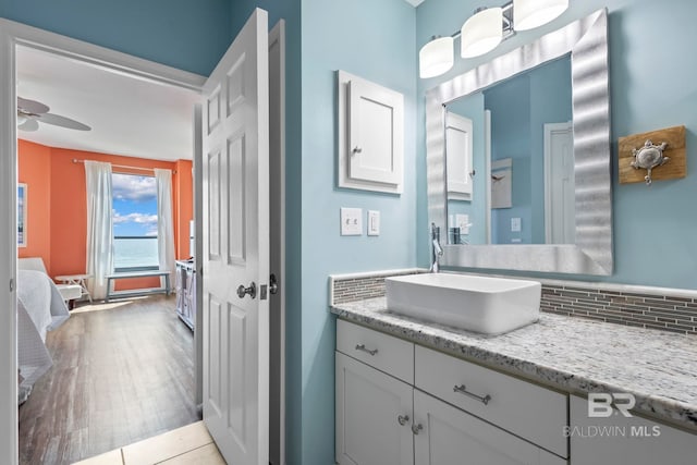 25250 Perdido Beach Blvd Unit 304E, Orange Beach, AL 36561 - bathroom featuring vanity, wood finished floors, ensuite bath, ceiling fan, and decorative backsplash