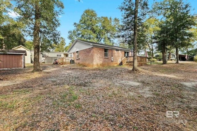 exterior space with a wooden deck and a shed