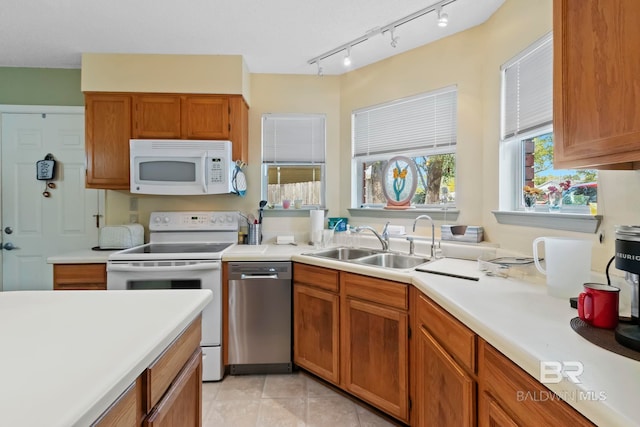 kitchen with sink, white appliances, and light tile patterned flooring