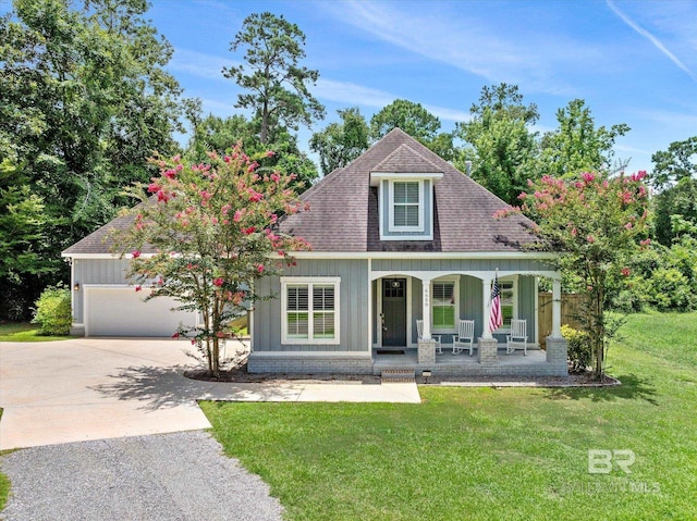 view of front facade with a garage, a porch, and a front lawn