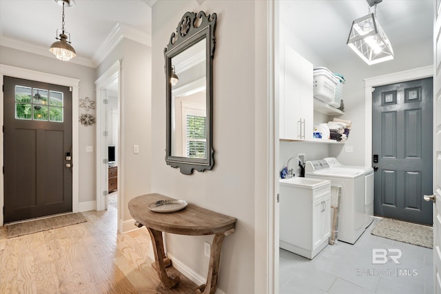 foyer entrance with washing machine and clothes dryer, light hardwood / wood-style floors, and crown molding