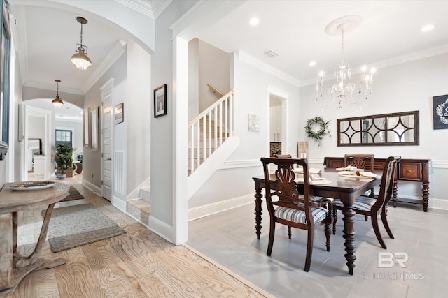 tiled dining space with crown molding and a chandelier