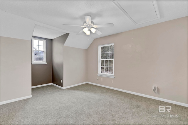 bonus room with vaulted ceiling, carpet flooring, and a textured ceiling