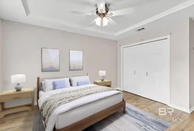 bedroom featuring ceiling fan, light hardwood / wood-style floors, and a closet