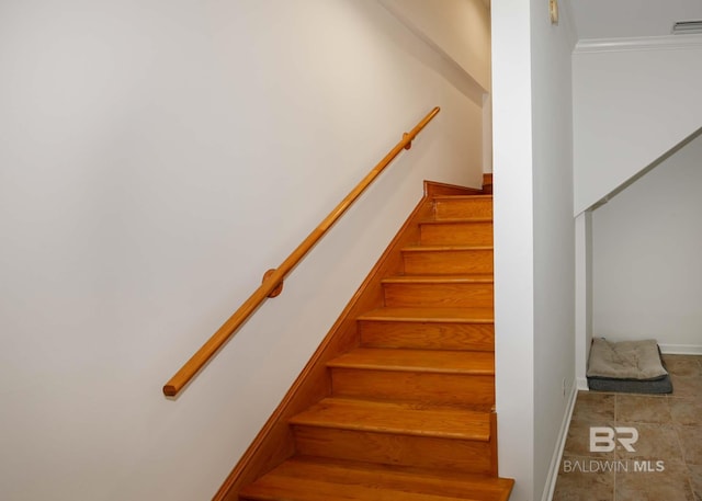 stairs with ornamental molding and tile patterned flooring