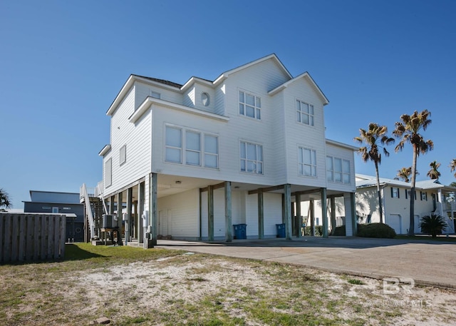 raised beach house featuring a patio area, a carport, and concrete driveway