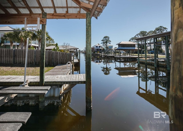 dock area with a water view and fence