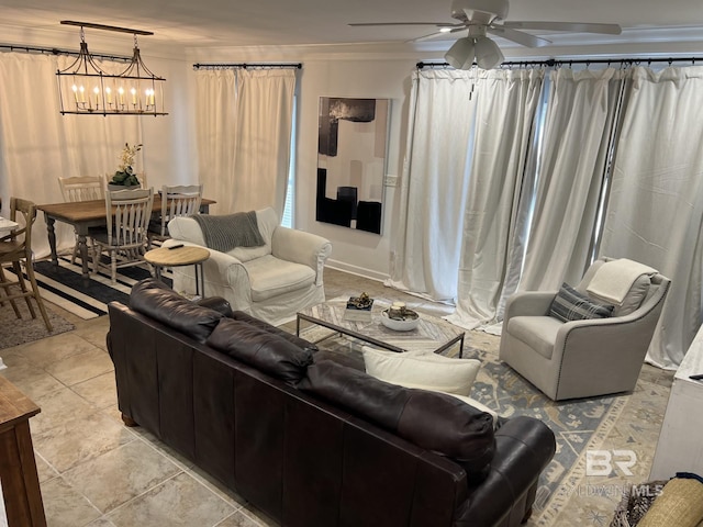 living room with crown molding and ceiling fan with notable chandelier