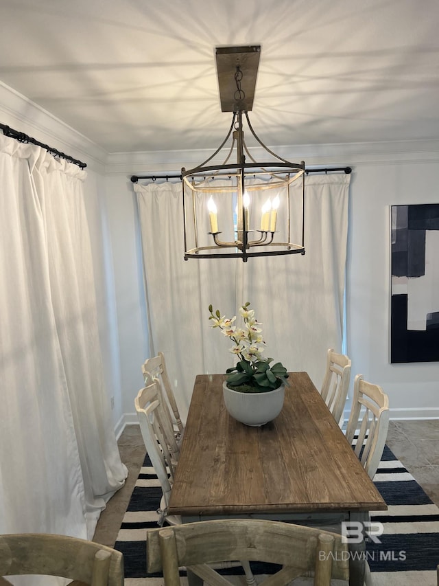 dining room with a notable chandelier, baseboards, and crown molding