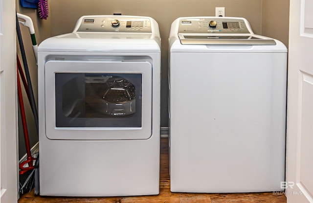 clothes washing area with wood-type flooring and separate washer and dryer